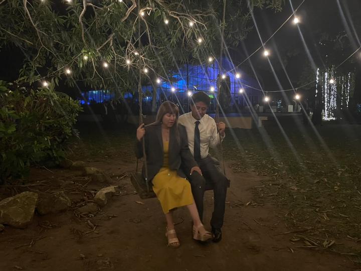 Two people sitting on a swing