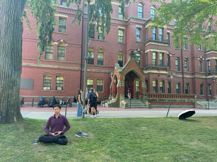 Student meditating in Harvard Yard