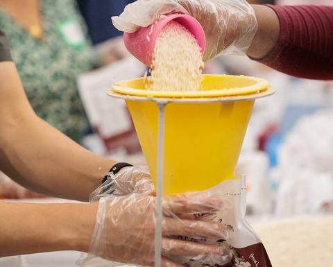 hands scooping rice into a container